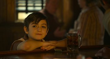 Movie still from “The Tender Bar” (2021), directed by George Clooney – A boy sitting at a table in front of a glass of soda; Close Up shot, Over the shoulder angle