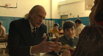 Movie still from “The Tender Bar” (2021), directed by George Clooney – An older man and a young boy sitting at a table in front of each other; Medium shot, Over the shoulder angle