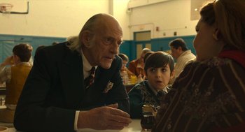 Movie still from “The Tender Bar” (2021), directed by George Clooney – An older man and a young boy sitting at a table; Close Up shot, Over the shoulder angle