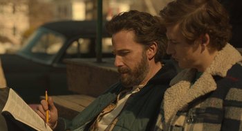 Movie still from “The Tender Bar” (2021), directed by George Clooney – A man and a woman sitting on a bench looking at something; Close Up shot, Over the shoulder angle