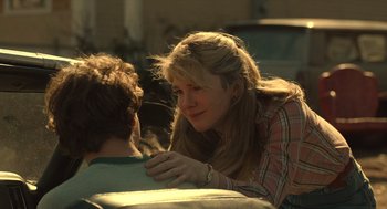 Movie still from “The Tender Bar” (2021), directed by George Clooney – A woman sitting next to a man on a bench; Close Up shot, Over the shoulder angle