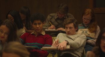 Movie still from “The Tender Bar” (2021), directed by George Clooney – A group of people sitting at a table with papers; Medium shot, High angle