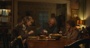 Movie still from “The Tender Bar” (2021), directed by George Clooney – A group of people sitting around a table eating food; Medium shot, High angle
