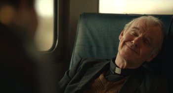 Movie still from “The Tender Bar” (2021), directed by George Clooney – An older man sitting in a chair with his eyes closed; Close Up shot, Over the shoulder angle