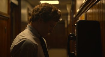 Movie still from “The Tender Bar” (2021), directed by George Clooney – A man in a tie is looking down at a phone; Close Up shot, Low angle