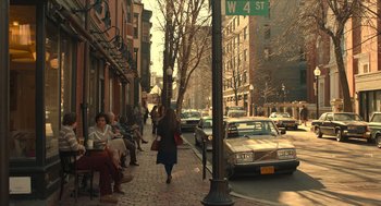 Movie still from “The Tender Bar” (2021), directed by George Clooney – A group of people walking down a sidewalk; Wide shot, High angle
