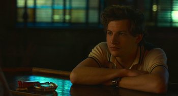 Movie still from “The Tender Bar” (2021), directed by George Clooney – A man sitting at a table in front of a window; Close Up shot, Over the shoulder angle