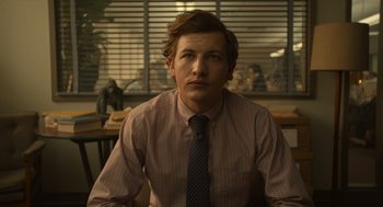 Movie still from “The Tender Bar” (2021), directed by George Clooney – A man wearing a striped shirt and a tie; Close Up shot, Low angle