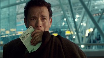 Movie still from “The Terminal” (2004), directed by Steven Spielberg – A man holding a piece of paper in front of his face; Close Up shot, Over the shoulder angle