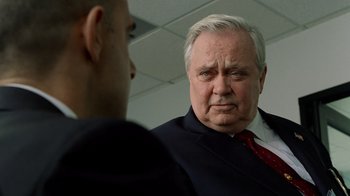 Movie still from “The Terminal” (2004), directed by Steven Spielberg – A man in a business suit and a man in a red tie; Close Up shot, Over the shoulder angle