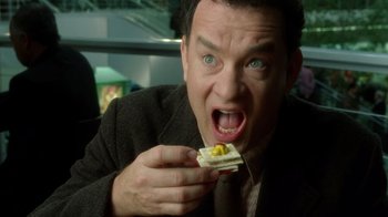 Movie still from “The Terminal” (2004), directed by Steven Spielberg – A person eating a sandwich; Close Up shot, Overhead angle