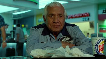 Movie still from “The Terminal” (2004), directed by Steven Spielberg – An older man sitting at a table in front of papers; Close Up shot, Low angle