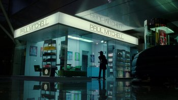 Movie still from “The Terminal” (2004), directed by Steven Spielberg – A person standing in front of a store; Extreme Wide shot, Overhead angle