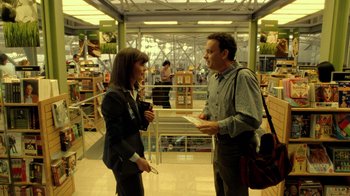 Movie still from “The Terminal” (2004), directed by Steven Spielberg – A man and a woman are talking in a store; Medium shot, Over the shoulder angle