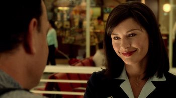 Movie still from “The Terminal” (2004), directed by Steven Spielberg – A woman in a suit smiling at a man; Close Up shot, Over the shoulder angle