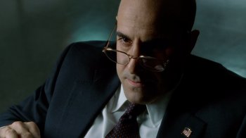 Movie still from “The Terminal” (2004), directed by Steven Spielberg – A man in a suit and tie wearing glasses; Close Up shot, Low angle