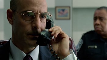 Movie still from “The Terminal” (2004), directed by Steven Spielberg – A man with glasses talking on a phone; Close Up shot, Low angle