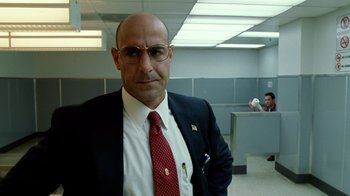 Movie still from “The Terminal” (2004), directed by Steven Spielberg – A man in a suit and tie in an office setting; Close Up shot, Low angle