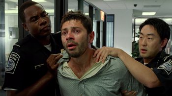 Movie still from “The Terminal” (2004), directed by Steven Spielberg – A man is being held down by a police officer; Close Up shot, Low angle