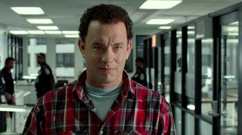 Movie still from “The Terminal” (2004), directed by Steven Spielberg – A man in a red and black plaid shirt is looking at the camera; Close Up shot, Over the shoulder angle