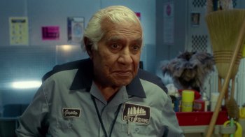 Movie still from “The Terminal” (2004), directed by Steven Spielberg – An older man with white hair wearing a gray shirt; Medium shot, Over the shoulder angle