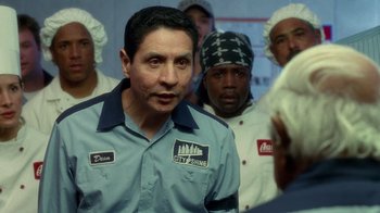 Movie still from “The Terminal” (2004), directed by Steven Spielberg – A group of men standing next to each other in a room; Close Up shot, Over the shoulder angle