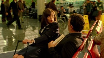 Movie still from “The Terminal” (2004), directed by Steven Spielberg – A man and a woman sitting on a red chair in an airport; Medium shot, High angle