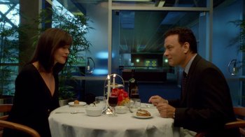 Movie still from “The Terminal” (2004), directed by Steven Spielberg – A man and a woman sitting at a table with food on it; Medium shot, Over the shoulder angle