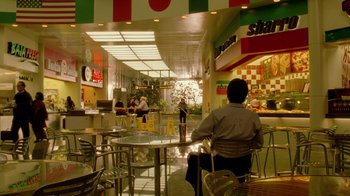 Movie still from “The Terminal” (2004), directed by Steven Spielberg – A person sitting at a table in a restaurant; Wide shot, High angle