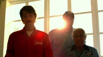 Movie still from “The Terminal” (2004), directed by Steven Spielberg – A group of men standing next to each other; Medium shot, Low angle