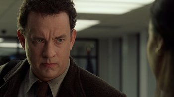 Movie still from “The Terminal” (2004), directed by Steven Spielberg – A man in a suit and tie in an office setting; Close Up shot, Low angle