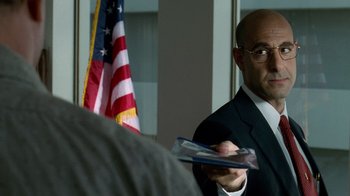 Movie still from “The Terminal” (2004), directed by Steven Spielberg – A man in a suit and tie holding a book; Close Up shot, Over the shoulder angle