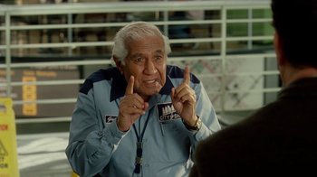 Movie still from “The Terminal” (2004), directed by Steven Spielberg – An older man is pointing up to the sky; Medium shot, Over the shoulder angle
