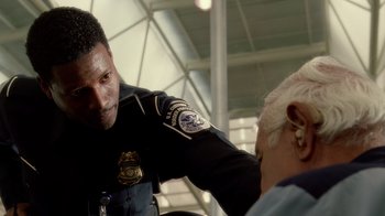 Movie still from “The Terminal” (2004), directed by Steven Spielberg – A police officer talking to an older woman; Close Up shot, Low angle