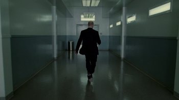 Movie still from “The Terminal” (2004), directed by Steven Spielberg – A man in a suit walking down a hall way; Wide shot, Low angle