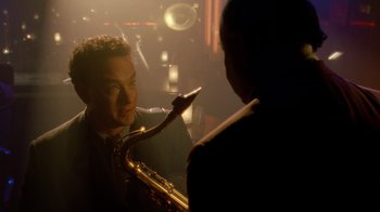 Movie still from “The Terminal” (2004), directed by Steven Spielberg – A man holding a saxophone while another man looks at him; Close Up shot, Over the shoulder angle