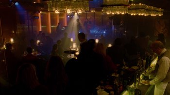 Movie still from “The Terminal” (2004), directed by Steven Spielberg – A group of people sitting at a table in a room; Extreme Wide shot, High angle