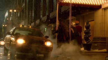 Movie still from “The Terminal” (2004), directed by Steven Spielberg – A yellow taxi cab driving down a street next to a street light; Extreme Wide shot, Low angle