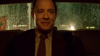 Movie still from “The Terminal” (2004), directed by Steven Spielberg – A man wearing a suit and tie standing in front of a window; Close Up shot, Low angle