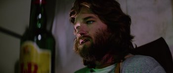 Movie still from “The Thing” (1982), directed by John Carpenter – A man with long hair and a beard stares ahead; Close Up shot, Low angle
