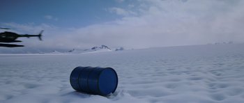 Movie still from “The Thing” (1982), directed by John Carpenter – A blue barrel sitting on top of a snow covered field; Extreme Wide shot, High angle