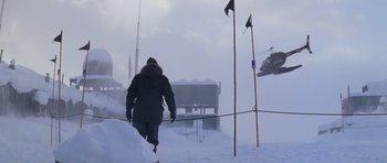 Movie still from “The Thing” (1982), directed by John Carpenter – A person walking in the snow with skis on; Extreme Wide shot, Low angle