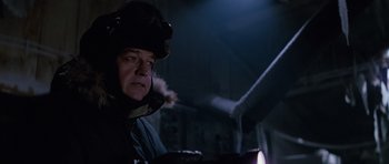 Movie still from “The Thing” (1982), directed by John Carpenter – An older man wearing a winter coat and a helmet; Close Up shot, Low angle