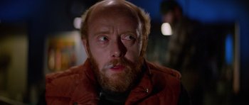 Movie still from “The Thing” (1982), directed by John Carpenter – A person with a beard; Close Up shot, Over the shoulder angle