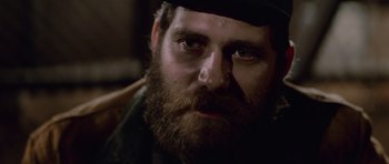 Movie still from “The Thing” (1982), directed by John Carpenter – A person with a beard; Close Up shot, Over the shoulder angle