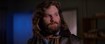 Movie still from “The Thing” (1982), directed by John Carpenter – A person with long hair and a beard; Close Up shot, Low angle