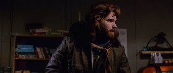 Movie still from “The Thing” (1982), directed by John Carpenter – A man with long hair and a beard wearing a leather jacket; Close Up shot, Low angle
