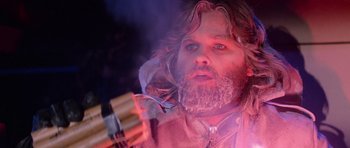 Movie still from “The Thing” (1982), directed by John Carpenter – A man with a beard holding a fork in his hand; Close Up shot, Low angle