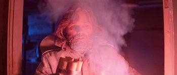 Movie still from “The Thing” (1982), directed by John Carpenter – A man with a long beard holding a candle in front of a fire; Close Up shot, Low angle
