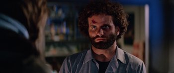 Movie still from “The Thing” (1982), directed by John Carpenter – A man with a beard and a face tattoo; Close Up shot, Low angle